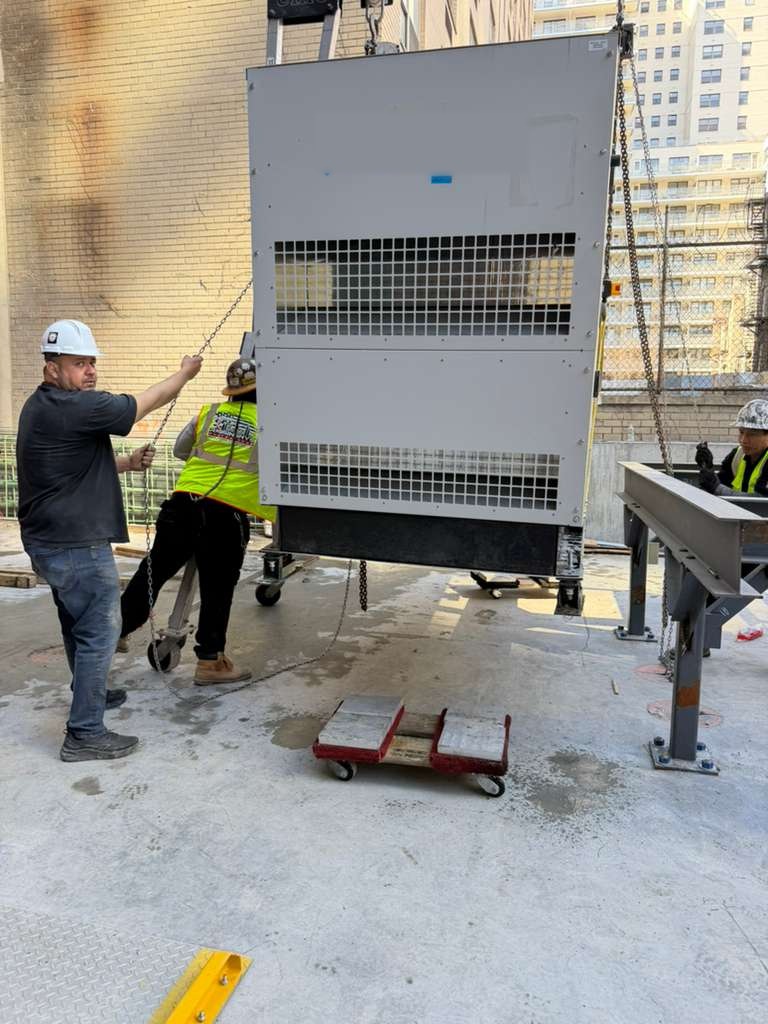 Riggers moving a standby generator with chain rigging on a NYC jobsite