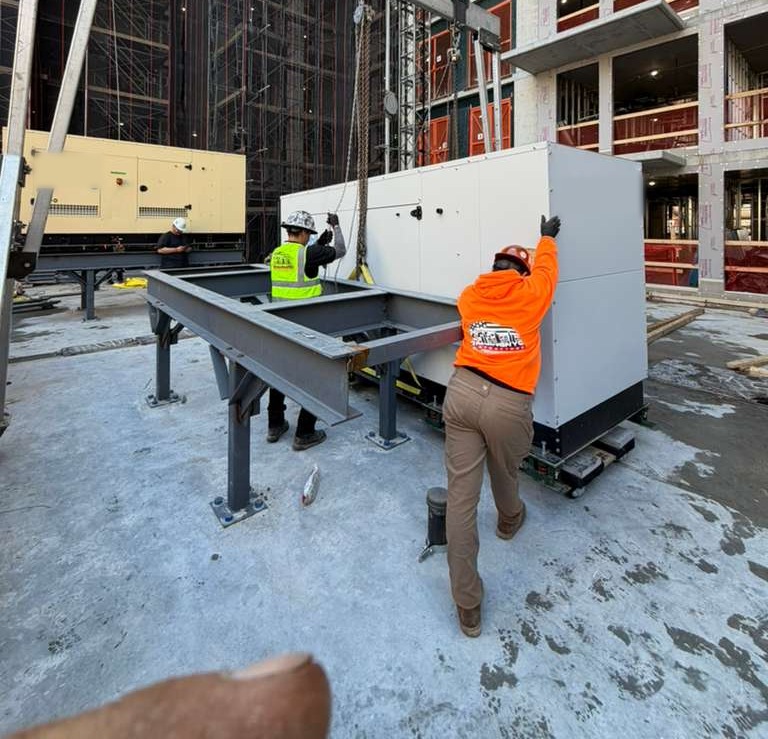 Riggers guiding a standby generator onto its steel platform at a NYC high-rise